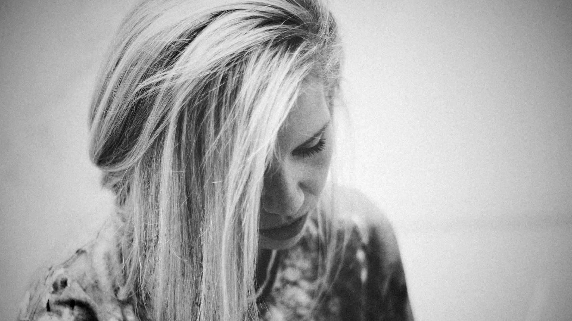 Black and white portrait of Emma Grzonkowski looking down, her blonde hair falling across her face
