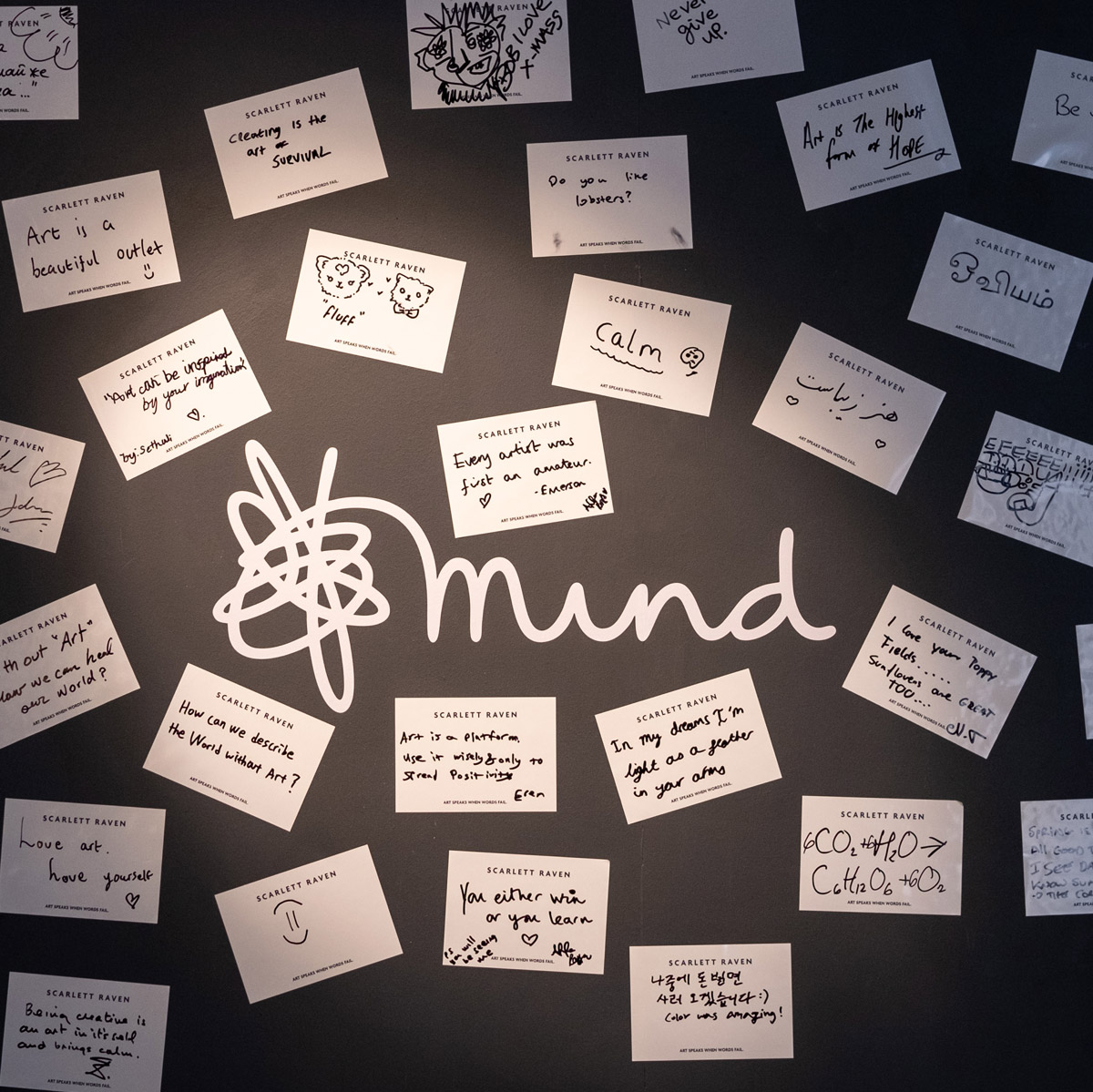 Mind charity logo on a black wall surrounded by handwritten visitor cards