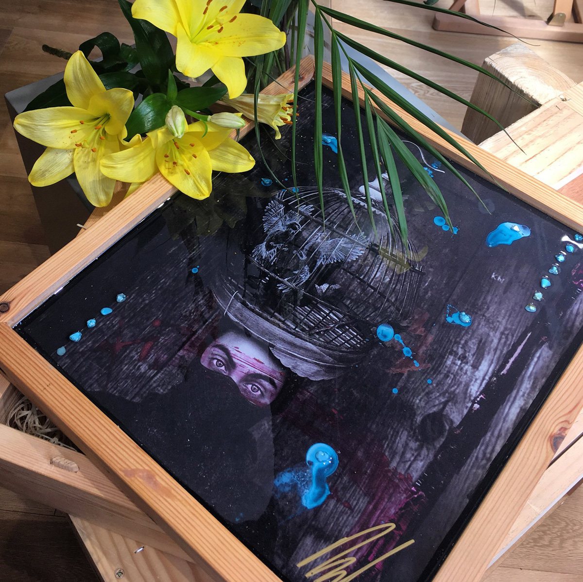 Limited-edition box with the artwork lid, lilies and palm leaves laid across it